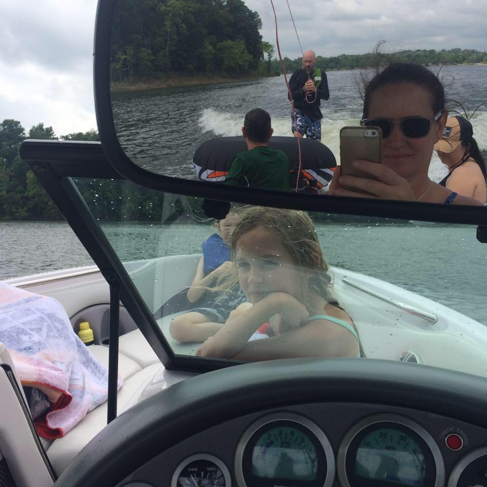 Small profile photo of a woman on a boat, used as a customer review avatar beside a testimonial on the Off Leash K9 Training Springfield, MO site.